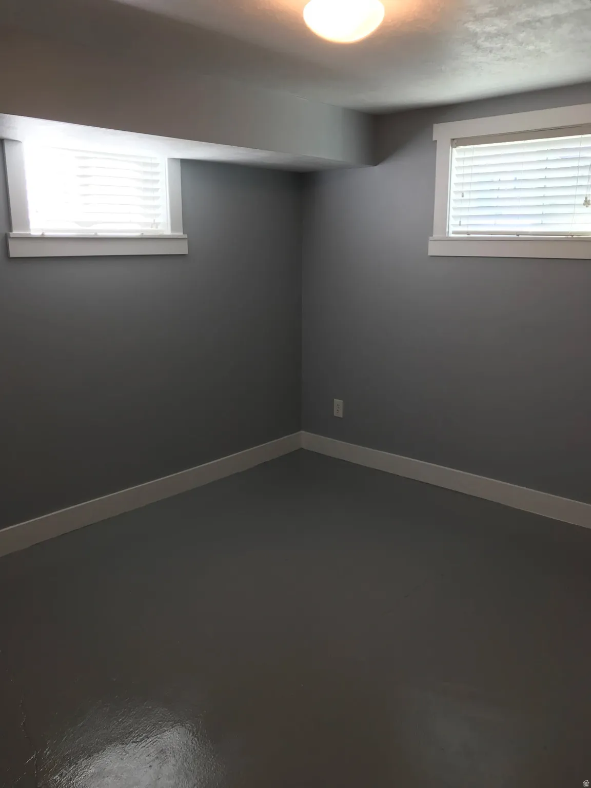 Unfurnished room featuring concrete flooring and baseboards