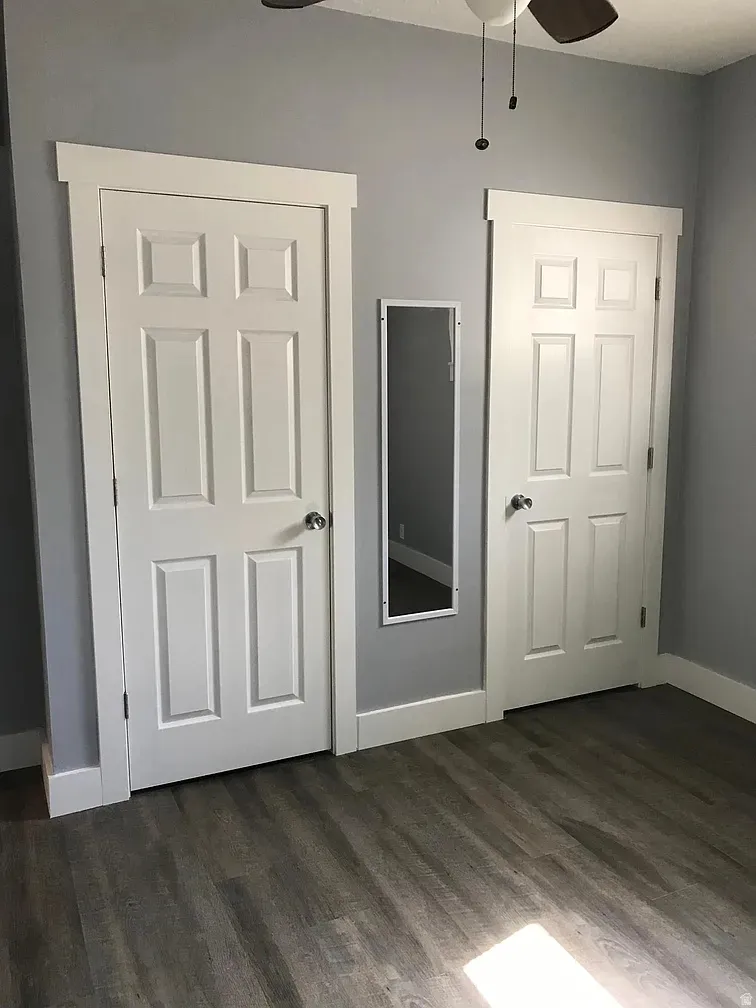 Unfurnished bedroom featuring dark wood finished floors and a ceiling fan