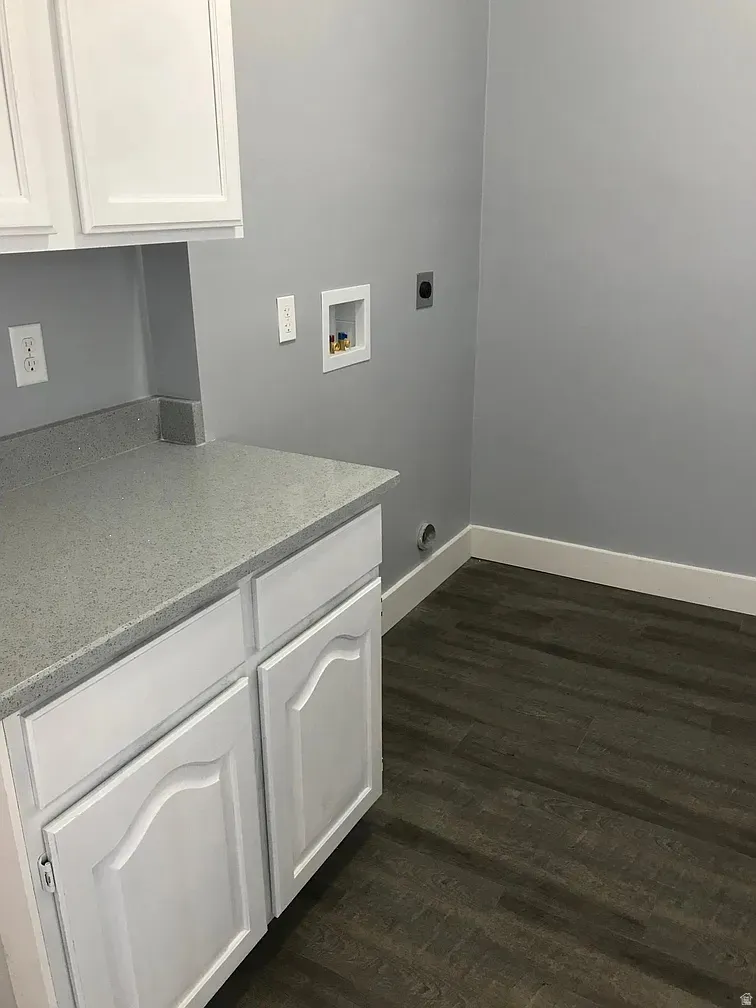 Laundry area with cabinet space, dark wood-type flooring, washer hookup, and electric dryer hookup