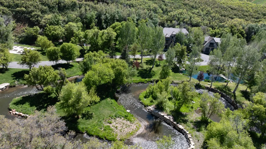 Aerial view of a heavily wooded area and a nearby body of water