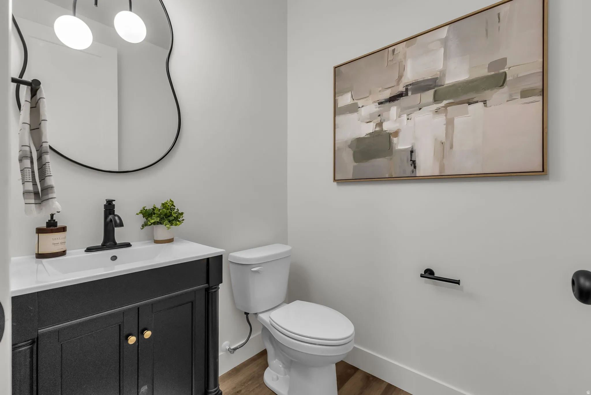 Half bathroom with vanity and wood finished floors
