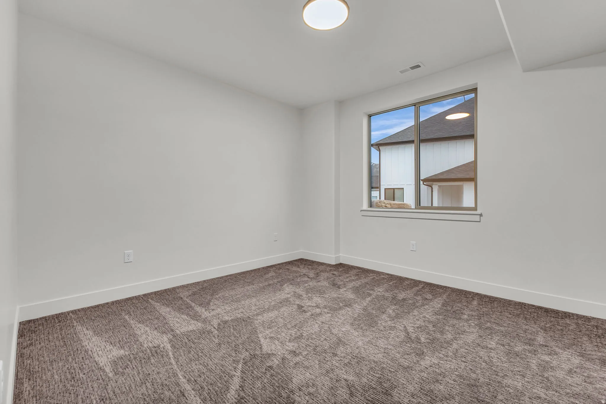 Empty room featuring baseboards and carpet floors