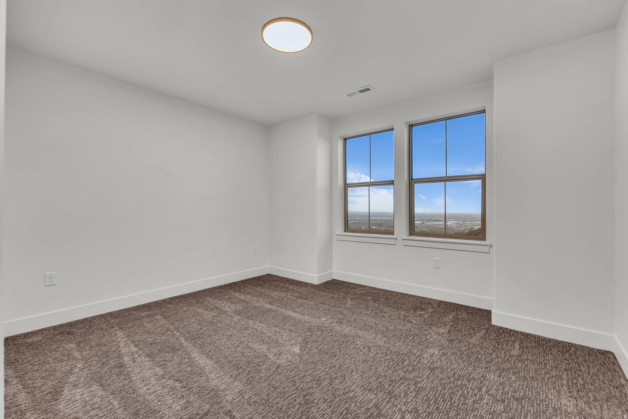 Unfurnished room with baseboards and dark carpet
