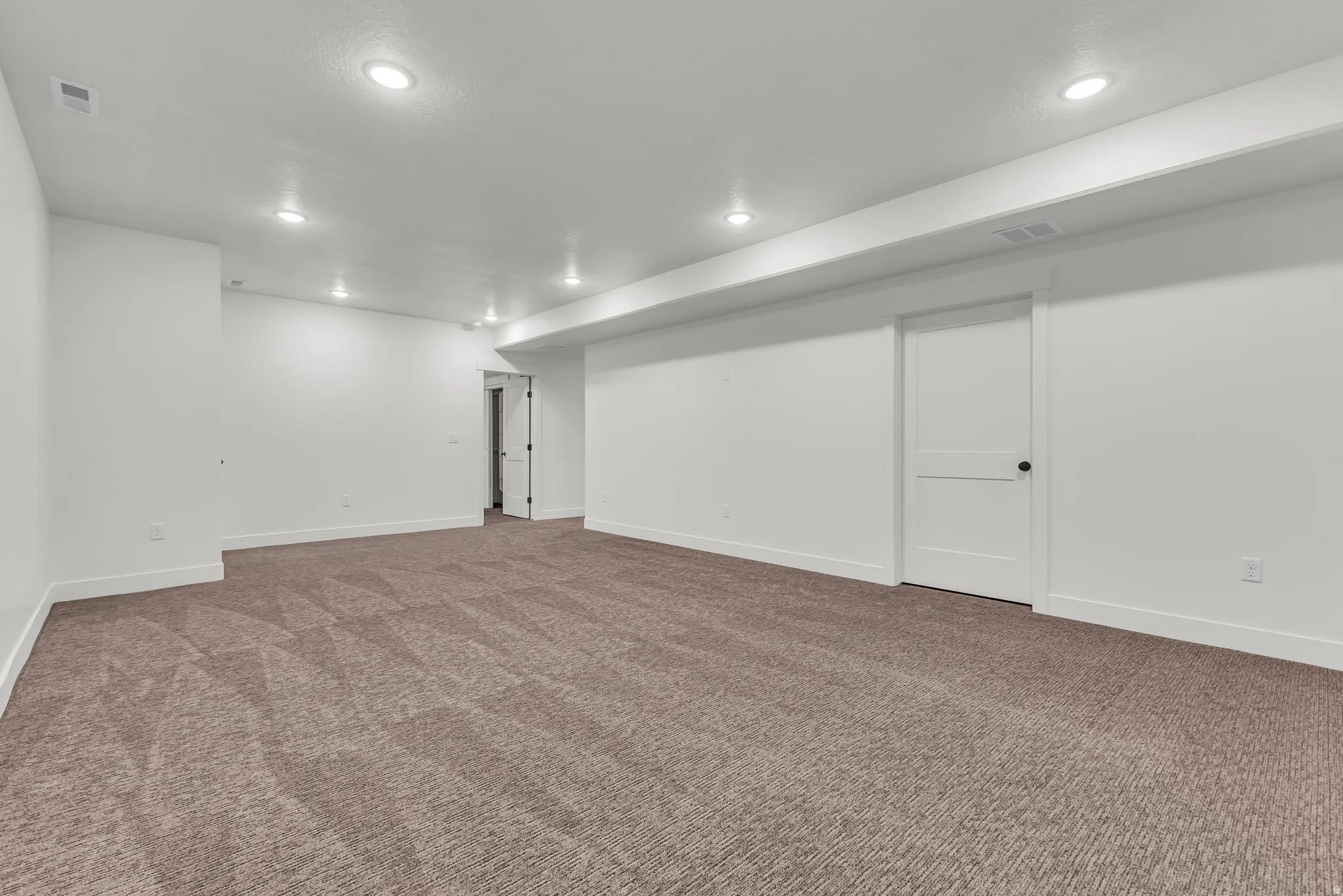 Finished basement featuring recessed lighting and dark colored carpet