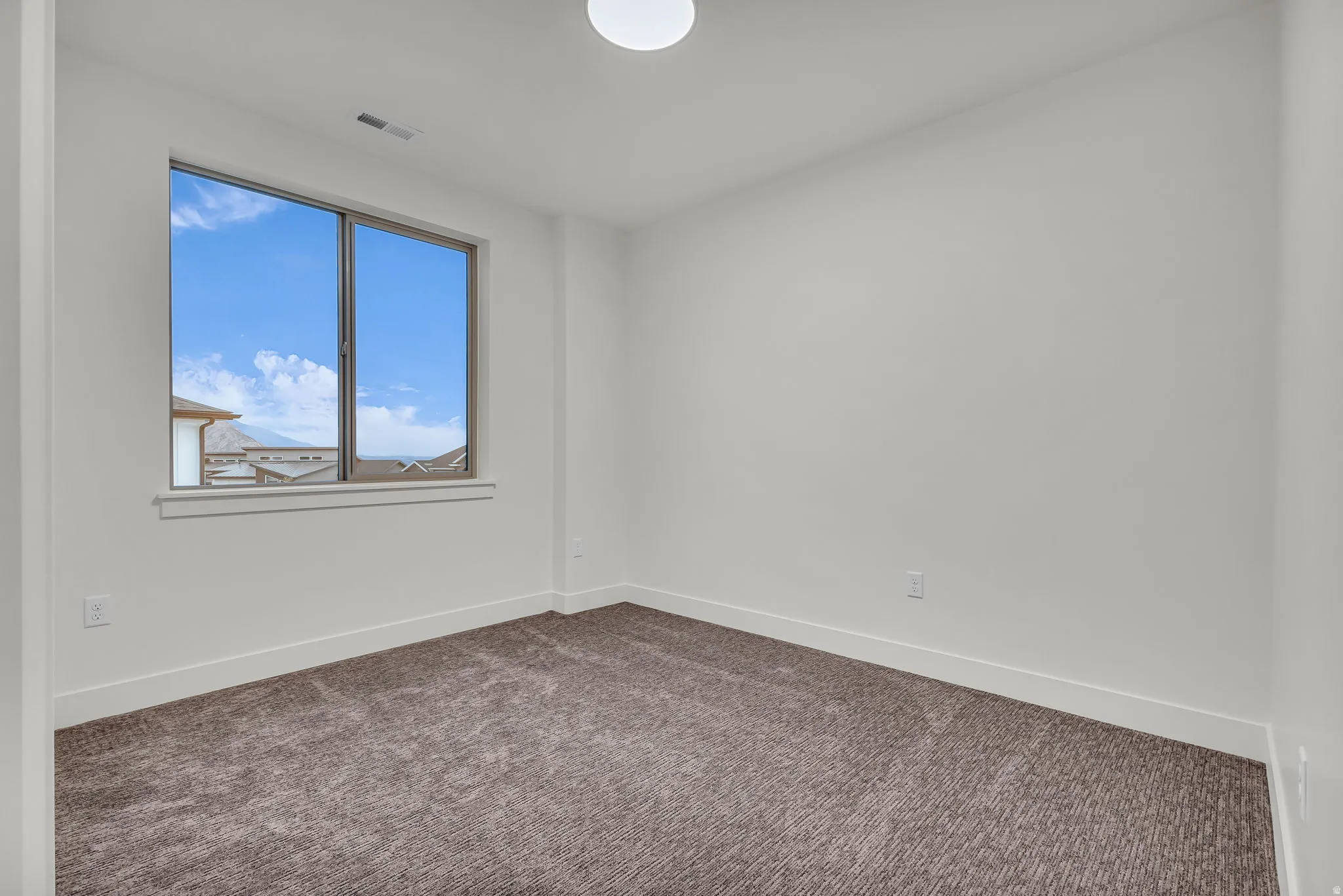Spare room with baseboards and dark carpet