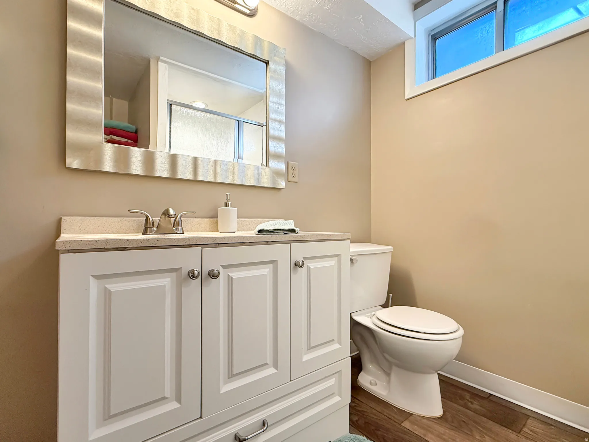 Bathroom with vanity, dark wood finished floors, and a shower with shower door