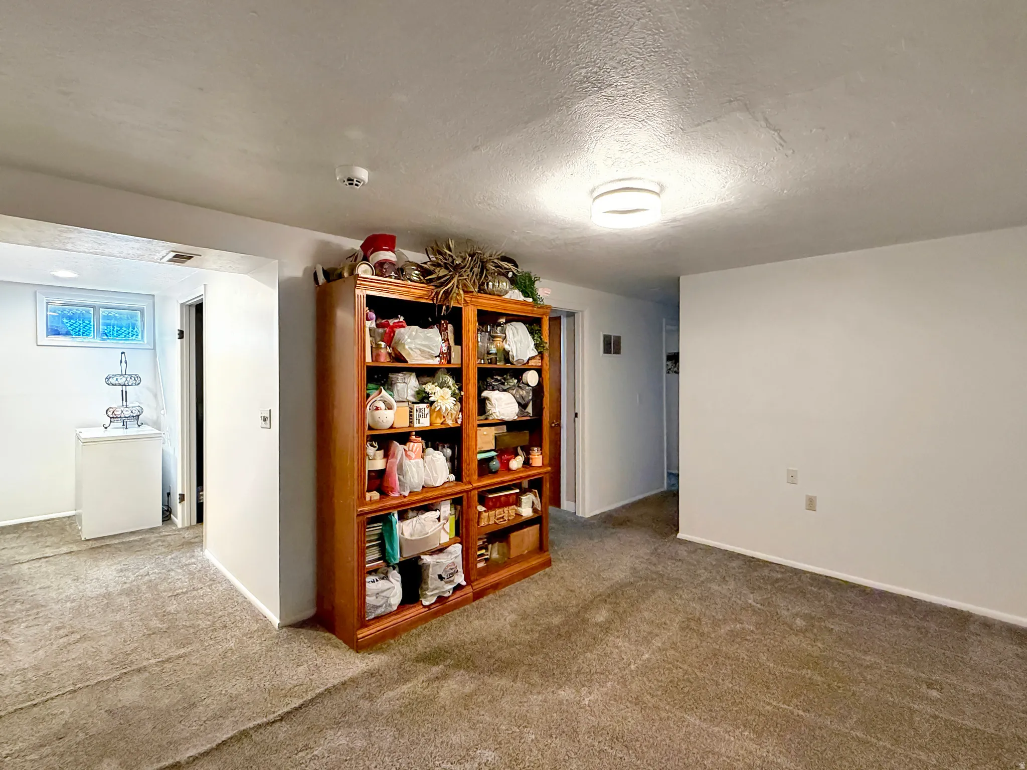 Empty room with carpet and a textured ceiling