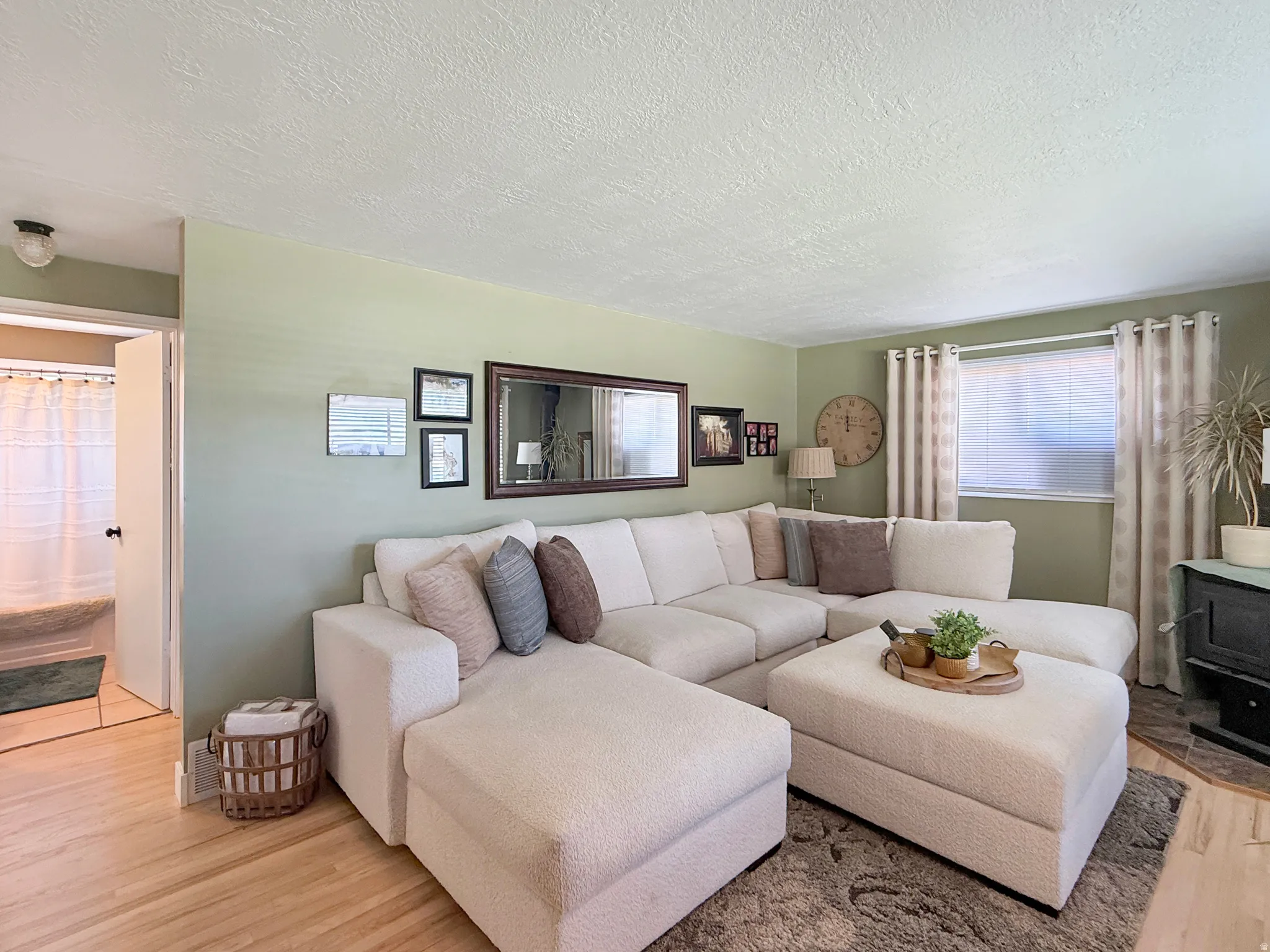 Living room featuring light wood-style floors and a textured ceiling