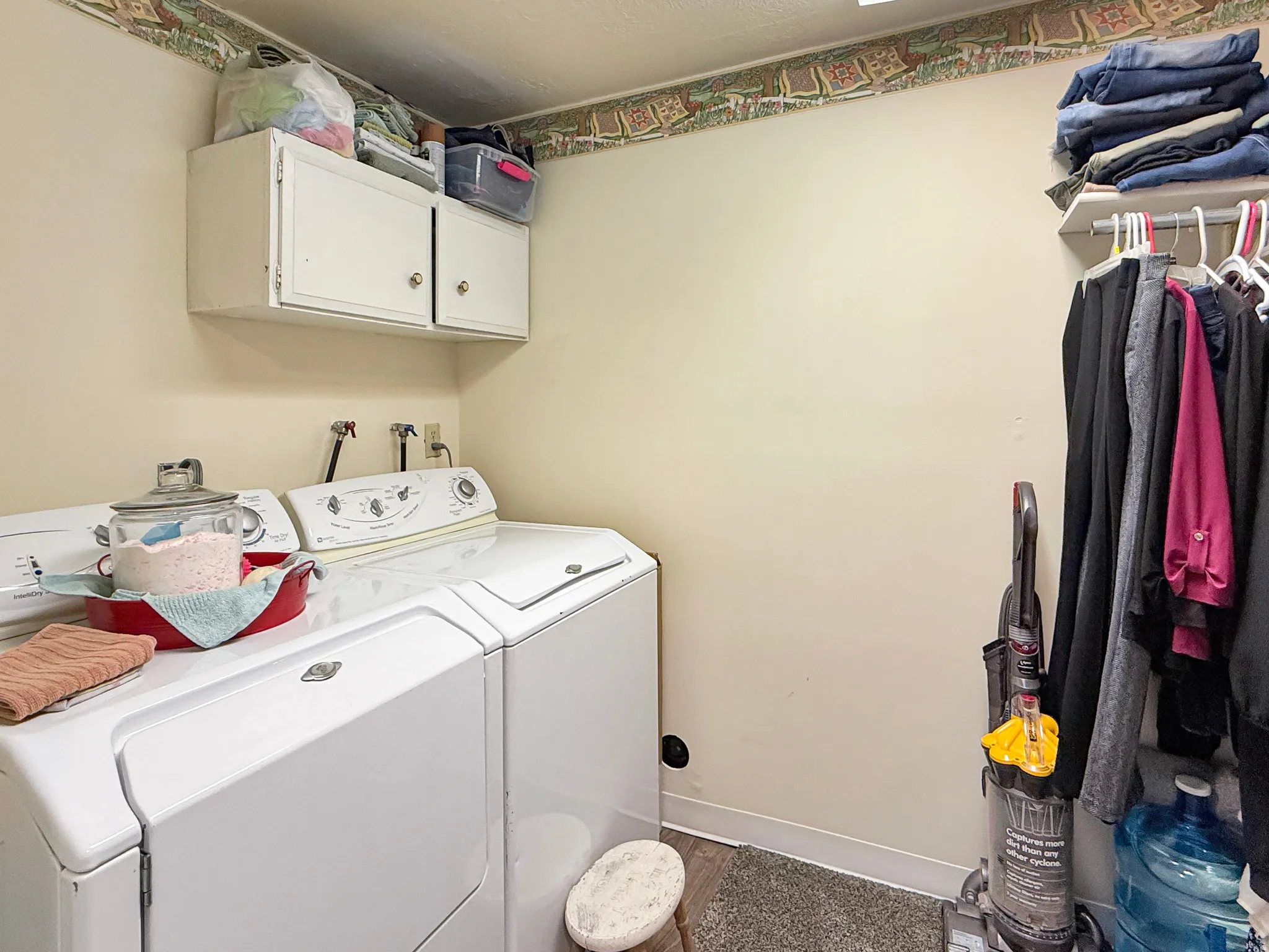 Laundry room featuring washing machine and dryer, wood finished floors, and cabinet space