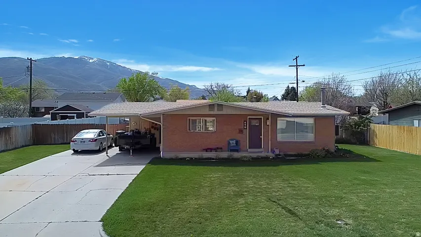 View of front of home featuring concrete driveway, an attached carport, and brick siding