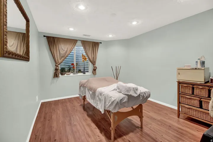 Bedroom with wood finished floors and recessed lighting
