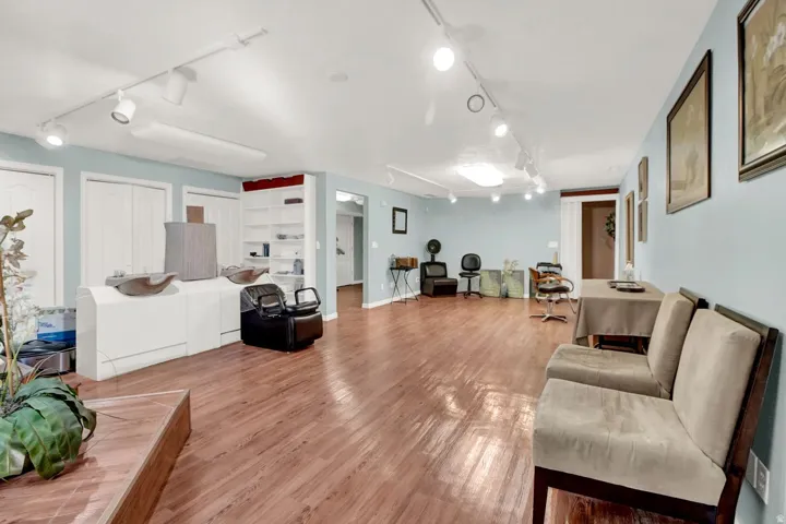 Living area featuring rail lighting and wood finished floors