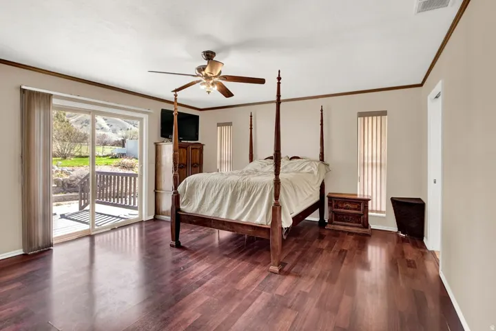 Bedroom featuring access to outside, ceiling fan, dark wood finished floors, and ornamental molding