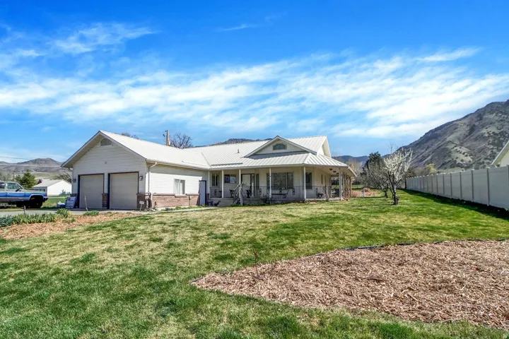 Rear view of property featuring a mountain view, a metal roof, covered porch, and brick siding