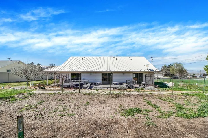 Back of house with a metal roof and a patio area