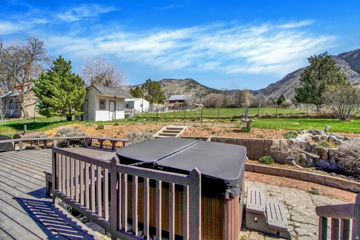 Wooden deck featuring a mountain view, an outbuilding, and a patio area