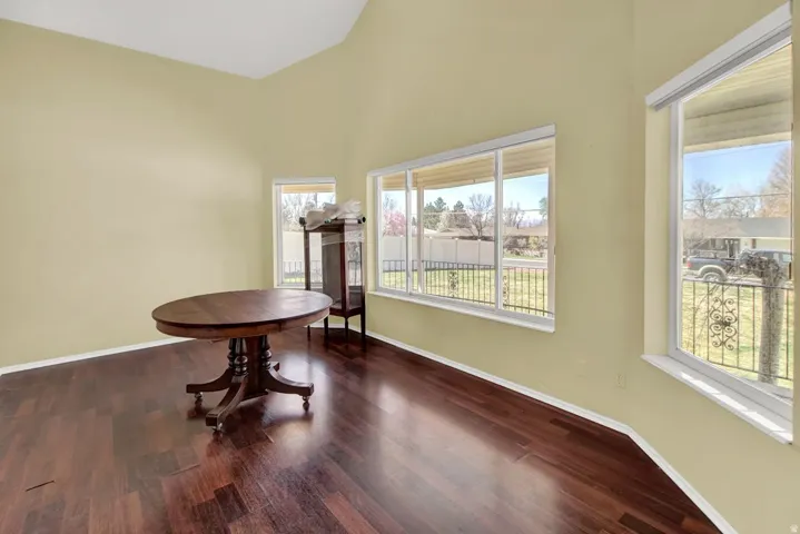 Dining room featuring dark wood-type flooring and lofted ceiling