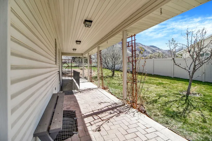 Fenced backyard with a mountain view and a patio area