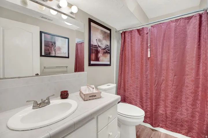 Full bath featuring vanity, a shower with shower curtain, and light wood finished floors