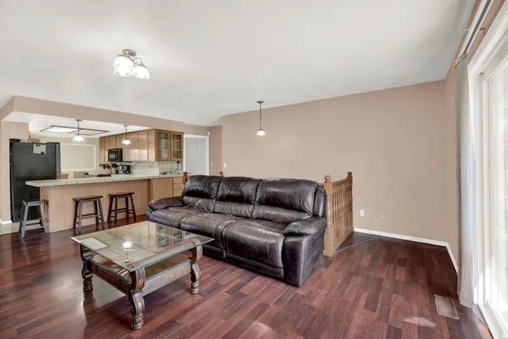 Living area featuring dark wood-style flooring and ceiling fan