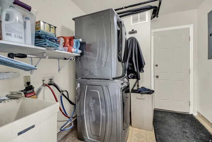 Laundry area with stacked washer / dryer and light flooring