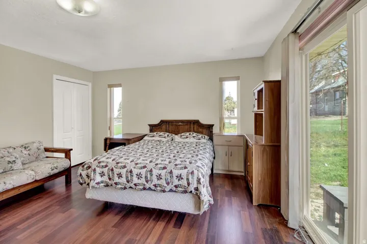 Bedroom with dark wood finished floors and a closet
