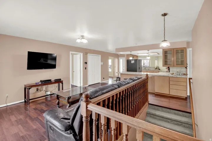 Living area with dark wood-style floors and a ceiling fan