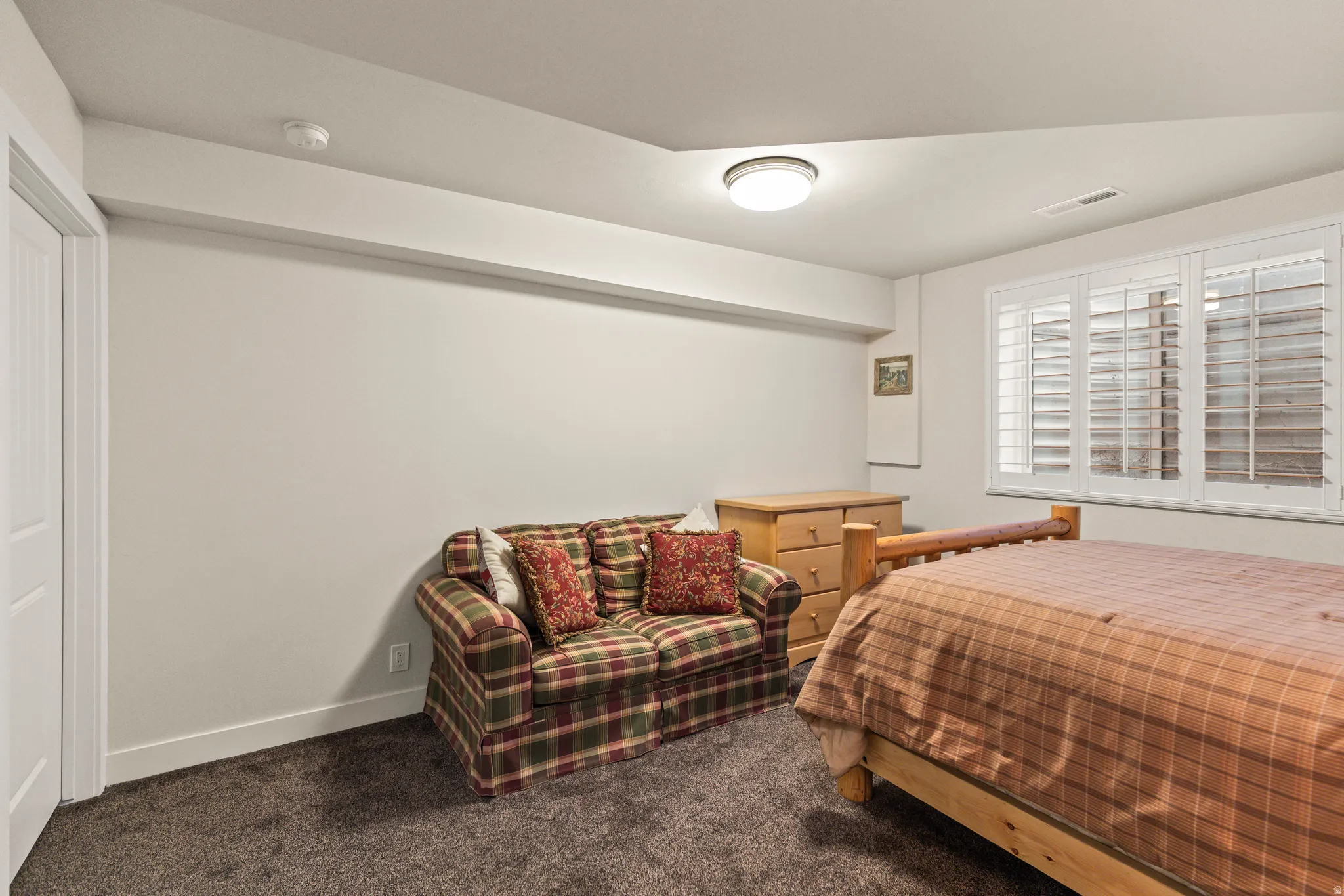 Bedroom featuring dark colored carpet and baseboards