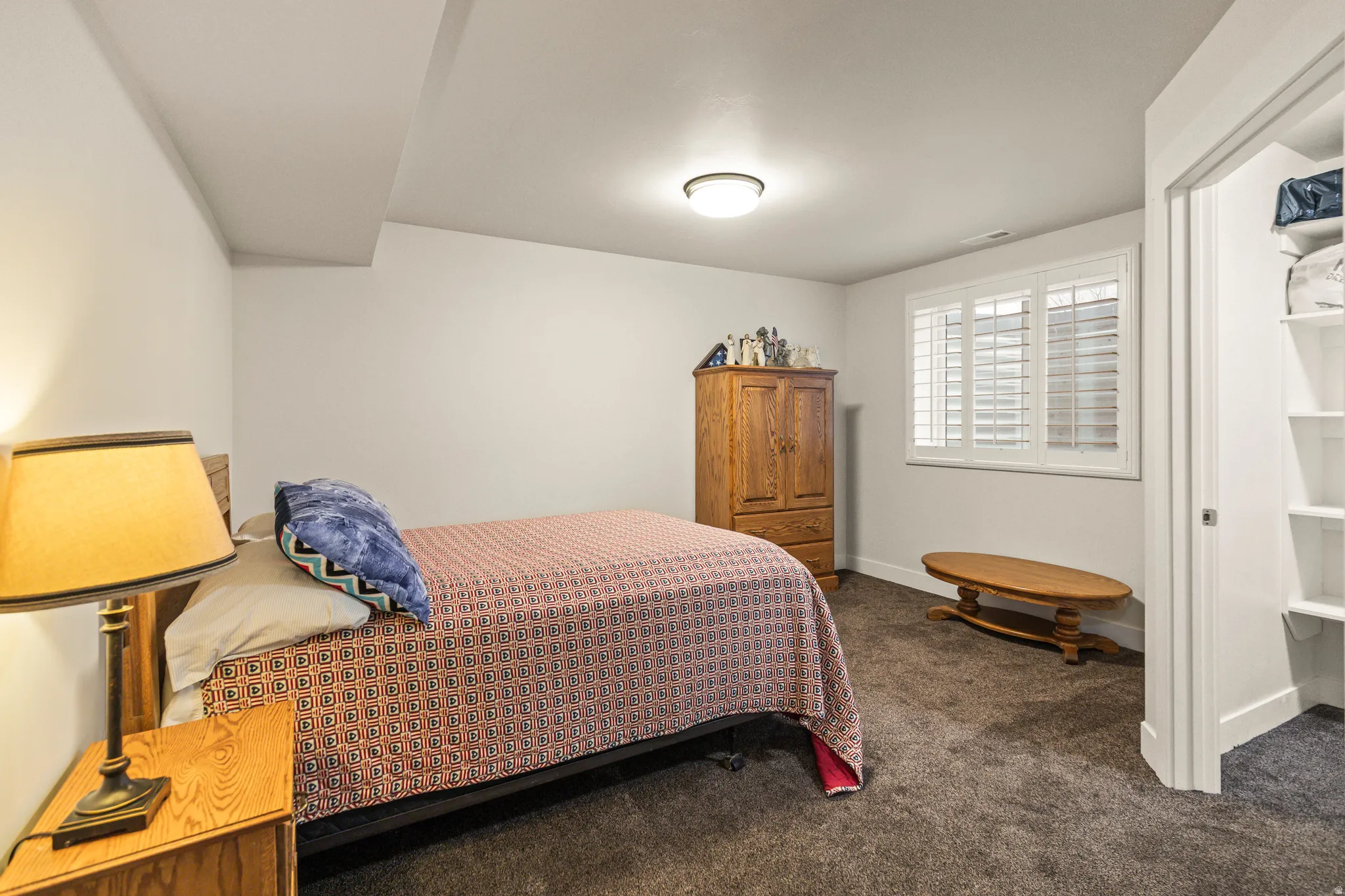 Bedroom with dark carpet and baseboards