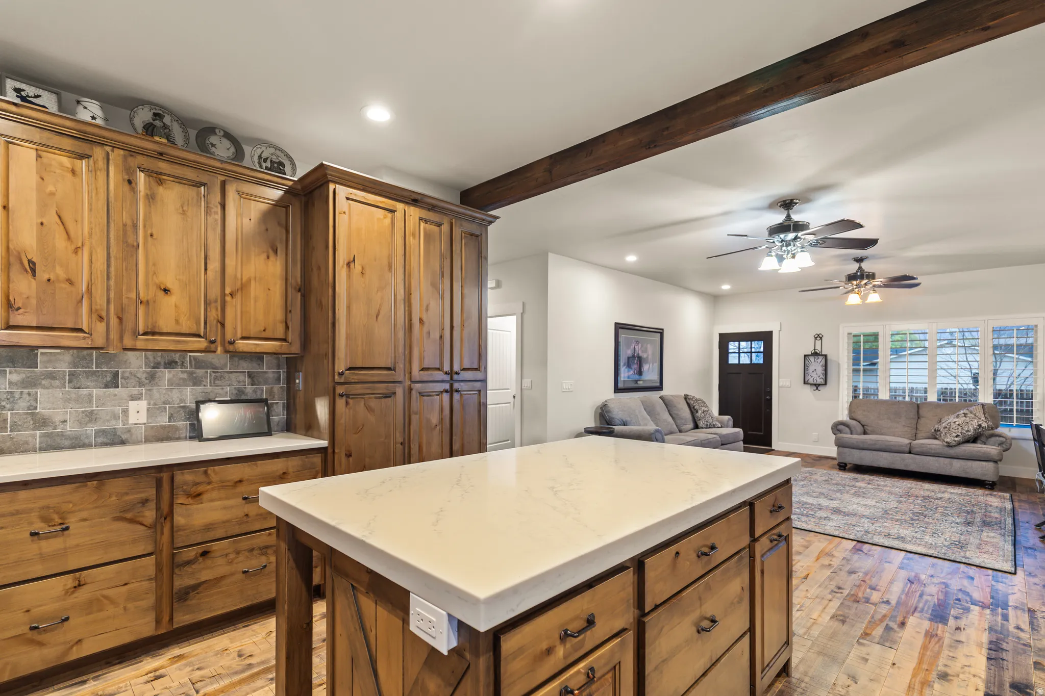Kitchen with wood finish cabinets, recessed lighting, open floor plan, backsplash, and ceiling fan