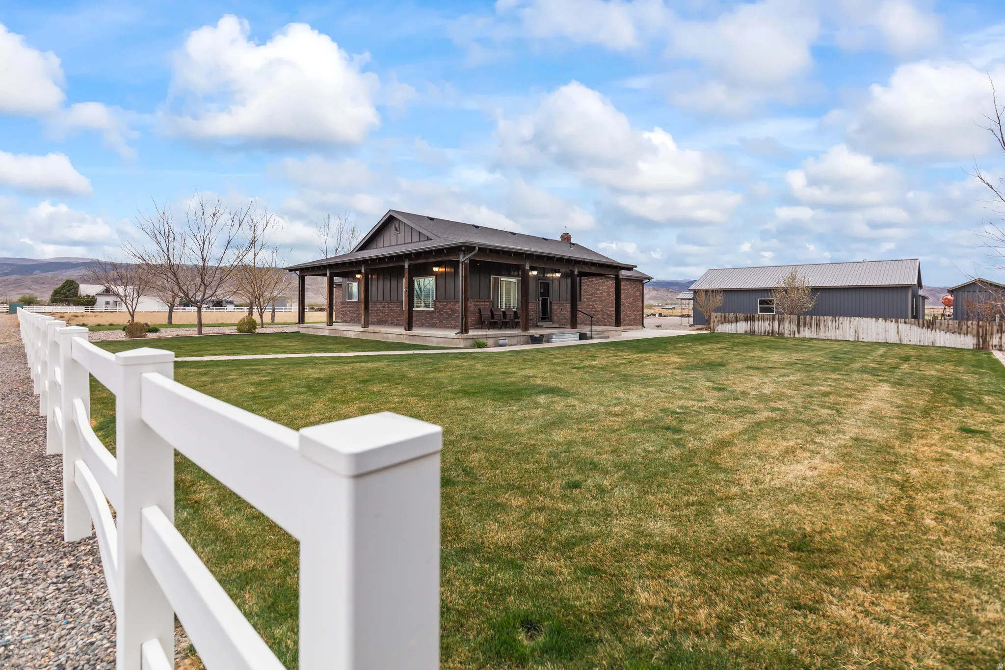 Back of house featuring brick siding, covered porch, board and batten siding, and a mountain view