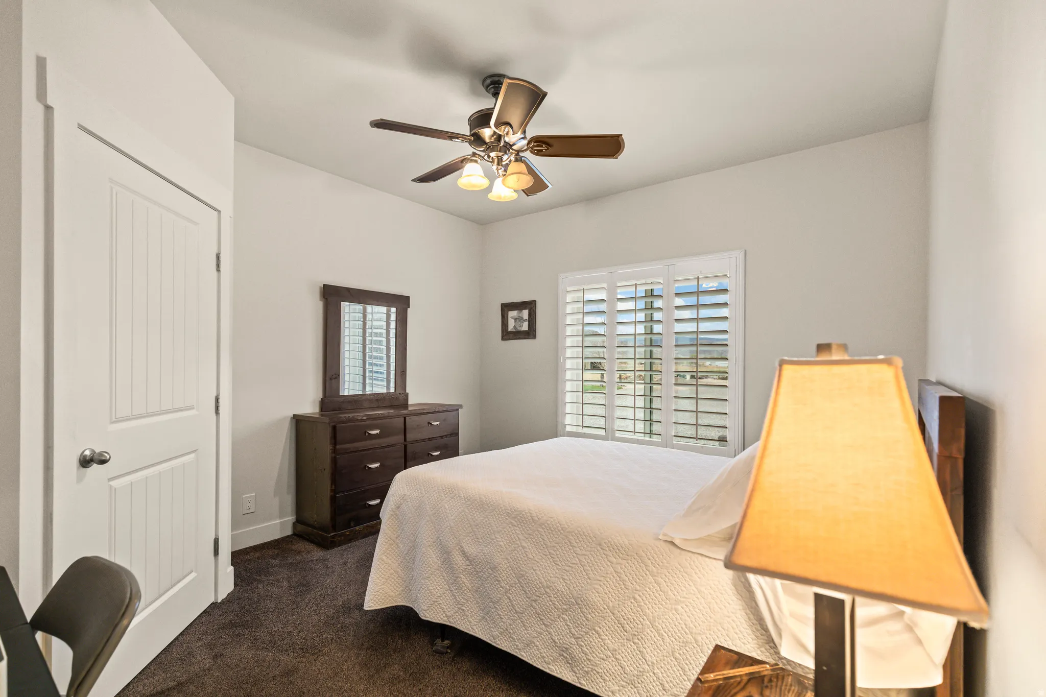 Bedroom featuring dark carpet and a ceiling fan
