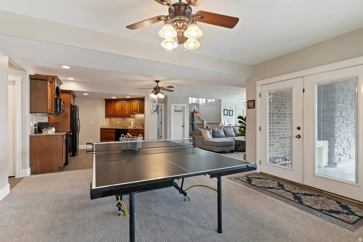 Recreation room with french doors, recessed lighting, dark colored carpet, and ceiling fan