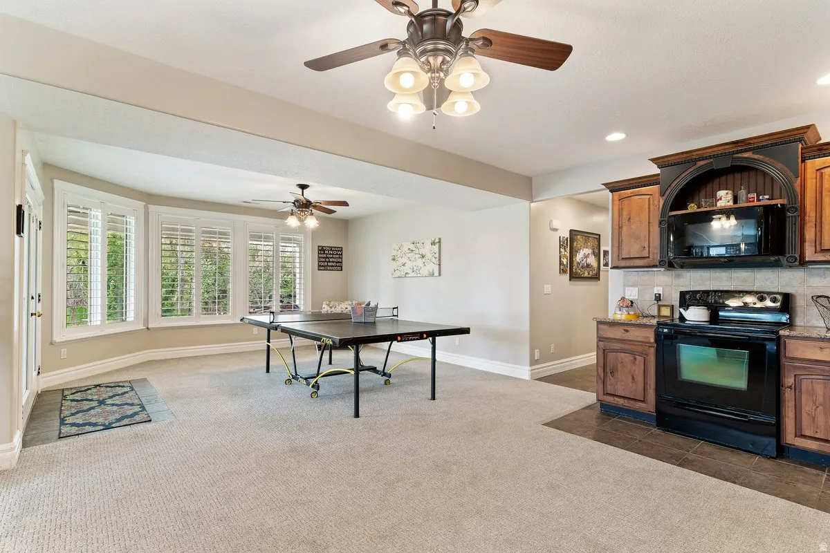 Kitchen with black appliances, decorative backsplash, dark colored carpet, a ceiling fan, and recessed lighting
