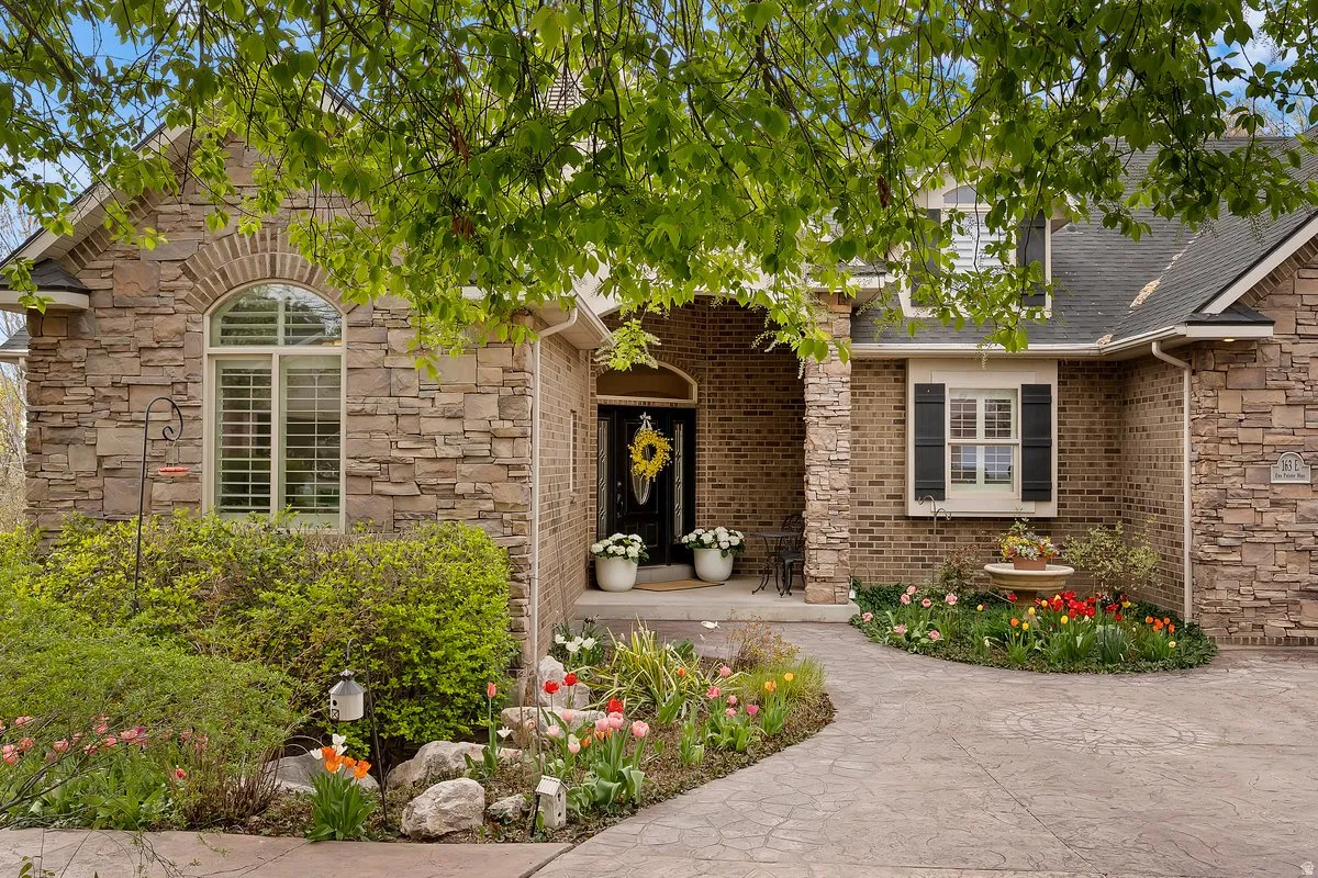 Property entrance with stone siding and roof with shingles