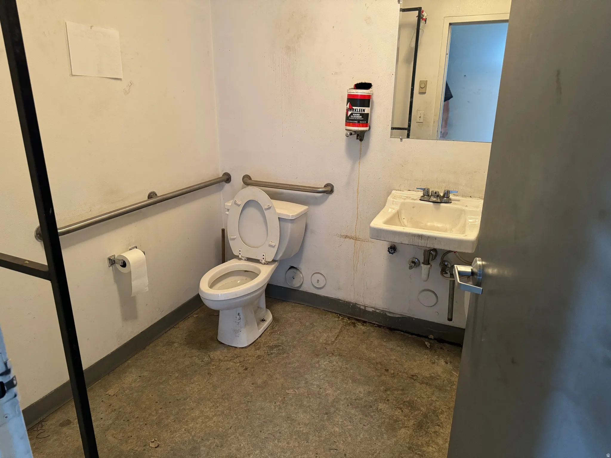 Bathroom featuring toilet and unfinished concrete flooring