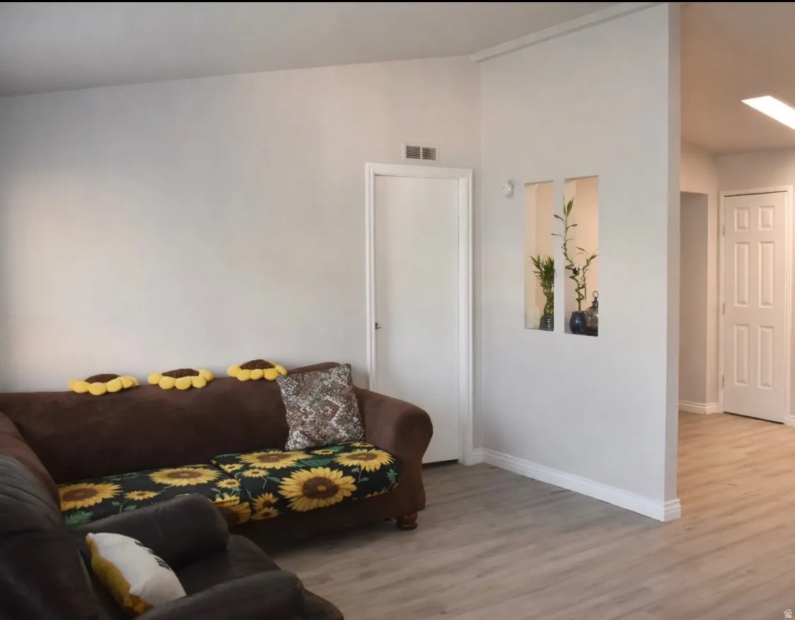 Living room with lofted ceiling and light wood finished floors