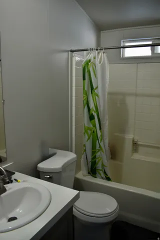 Full bath featuring vanity and shower / bathtub combination with curtain
