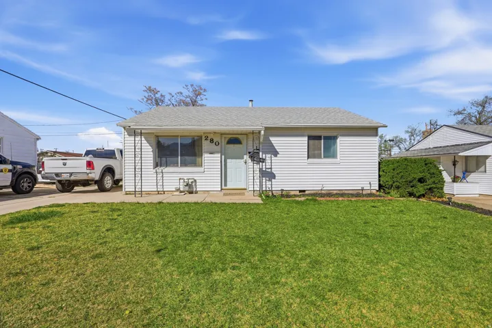 View of front of property with roof with shingles, a front lawn, and crawl space