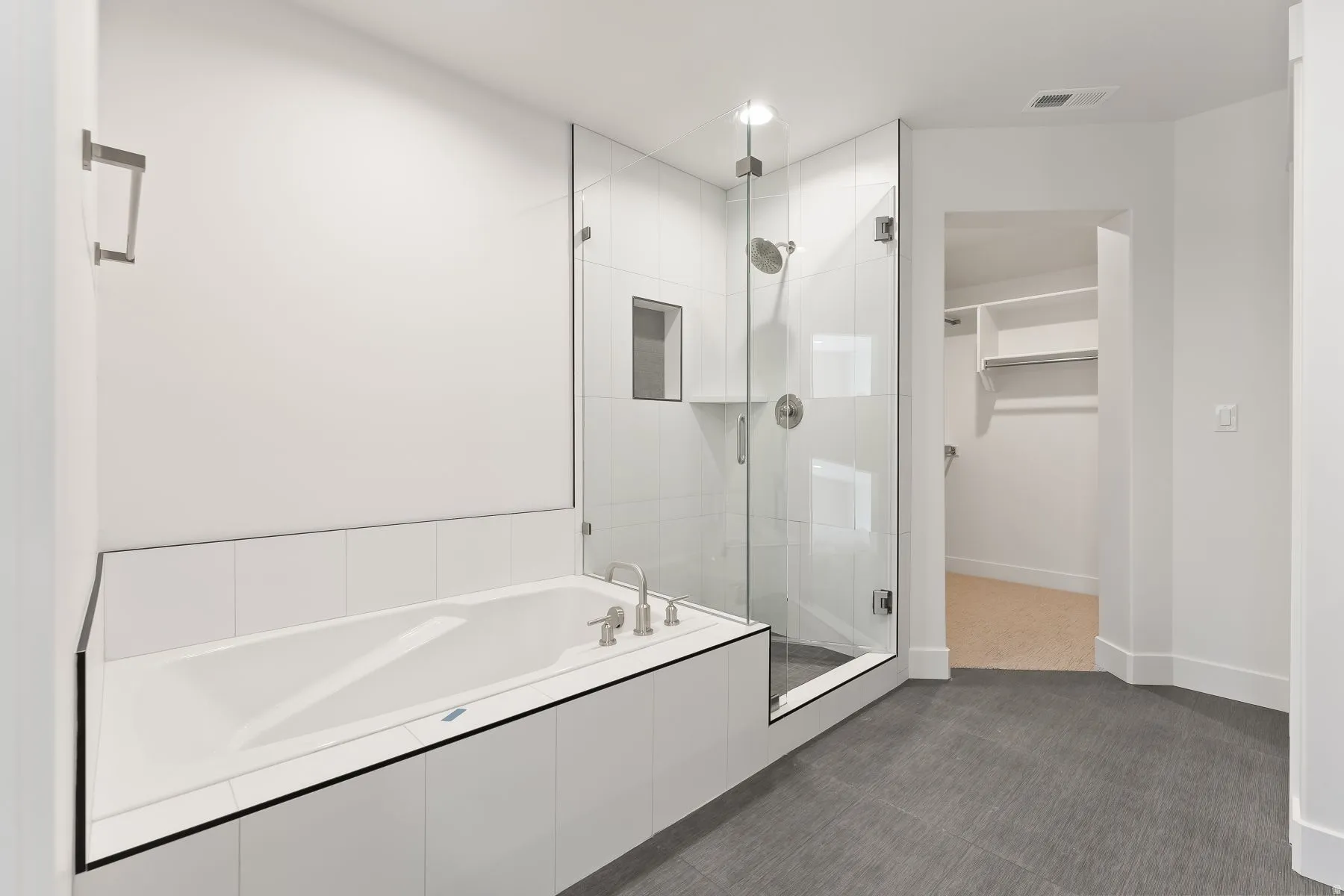 Bathroom featuring a spacious closet, a shower stall, and a bath