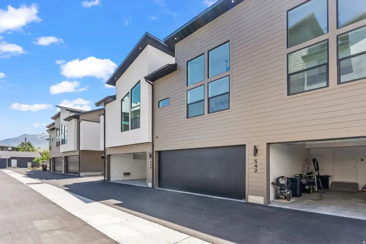 View of side of home with a mountain view, a garage, and stucco siding