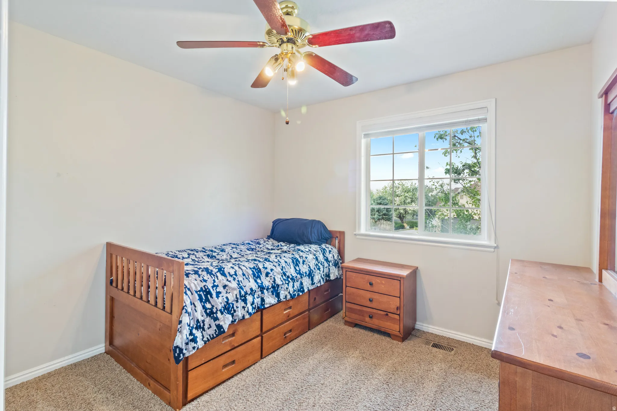 Bedroom with light colored carpet and ceiling fan