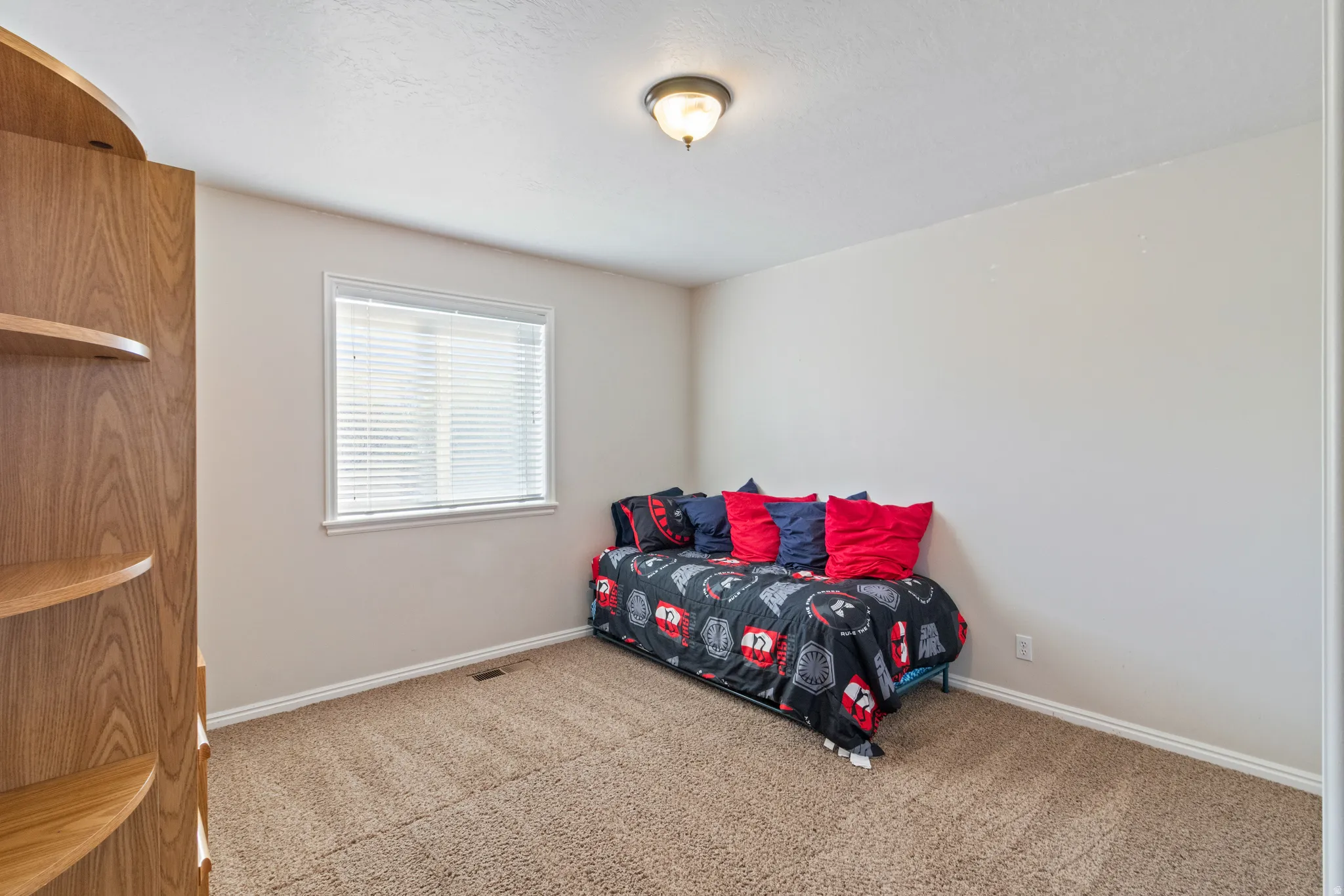 Bedroom featuring baseboards and light carpet