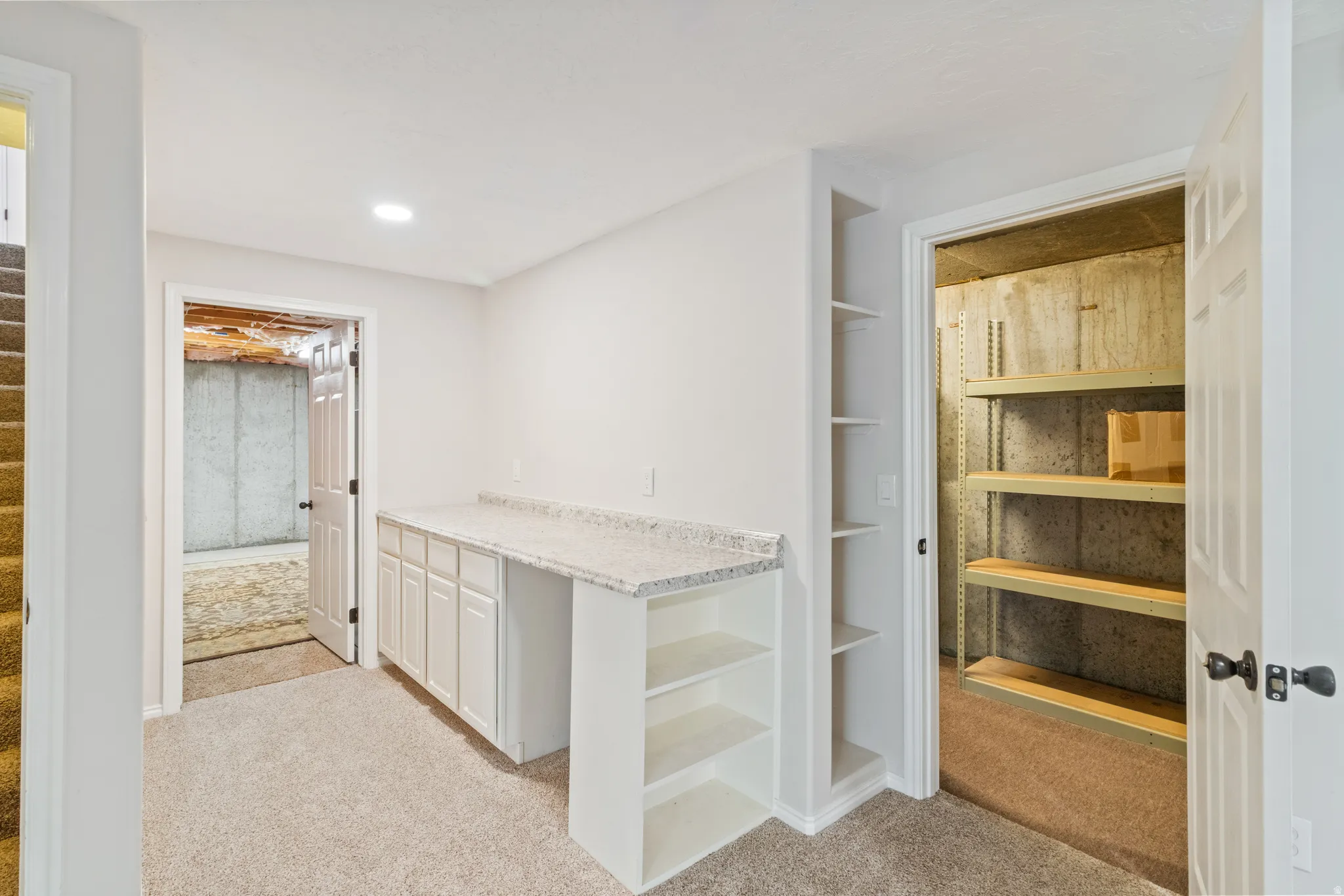 Bar with light carpet, light countertops, white cabinets, built in features, and recessed lighting