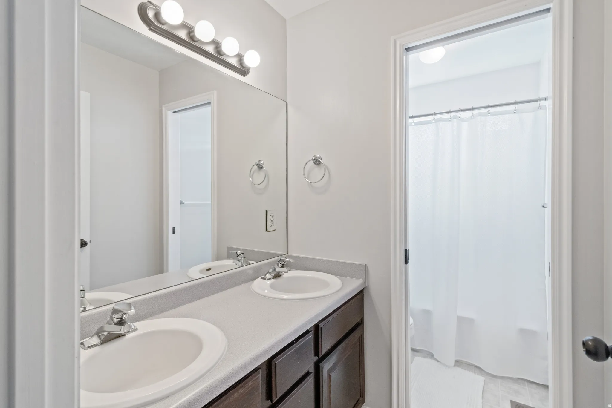 Bathroom with double vanity and shower / tub combo