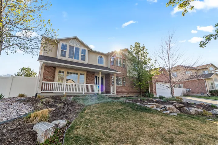 Traditional-style home featuring a porch, stucco siding, brick siding, and a garage