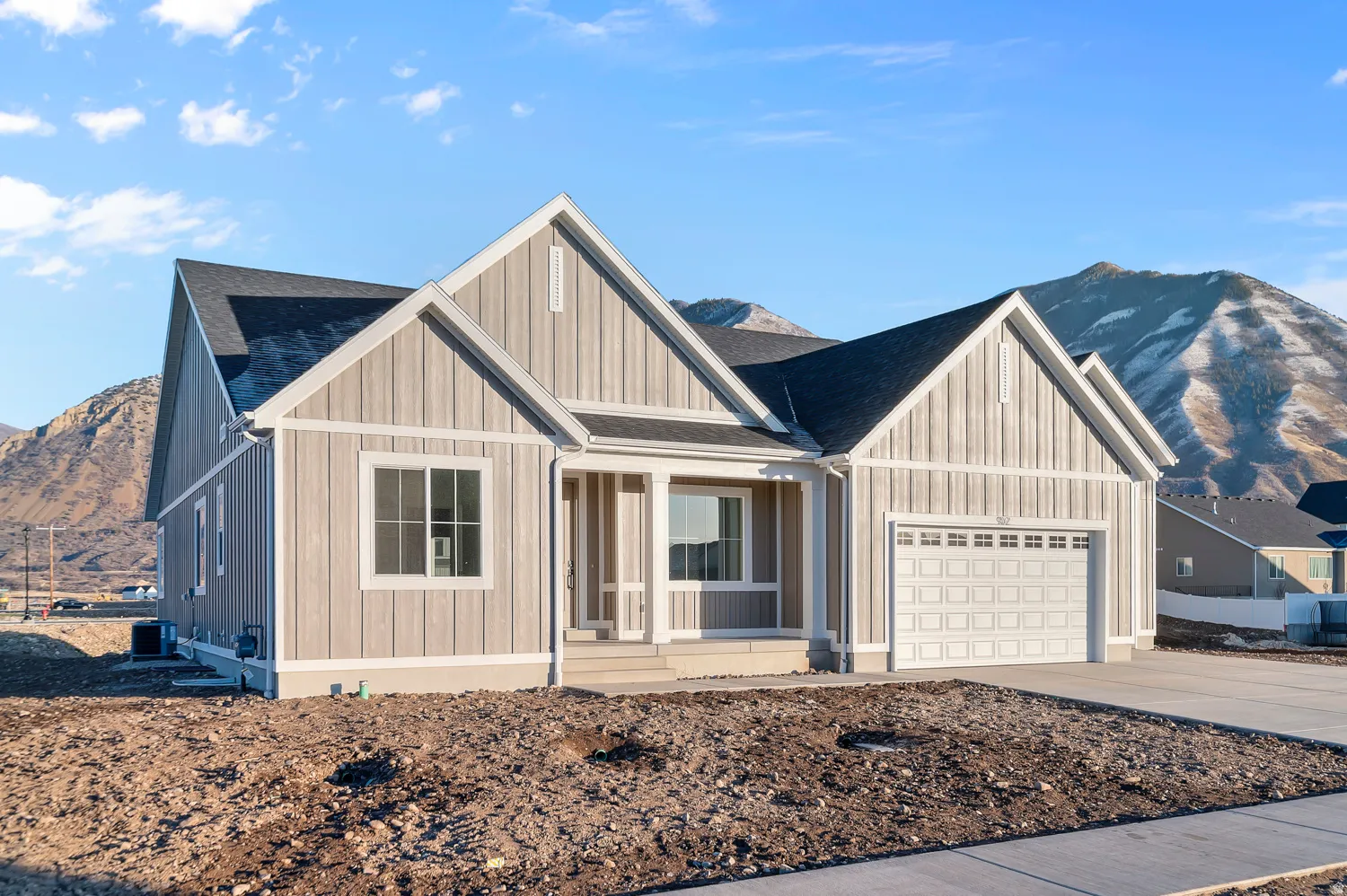View of front of property with a mountain view, covered porch, driveway, an attached garage, and roof with shingles