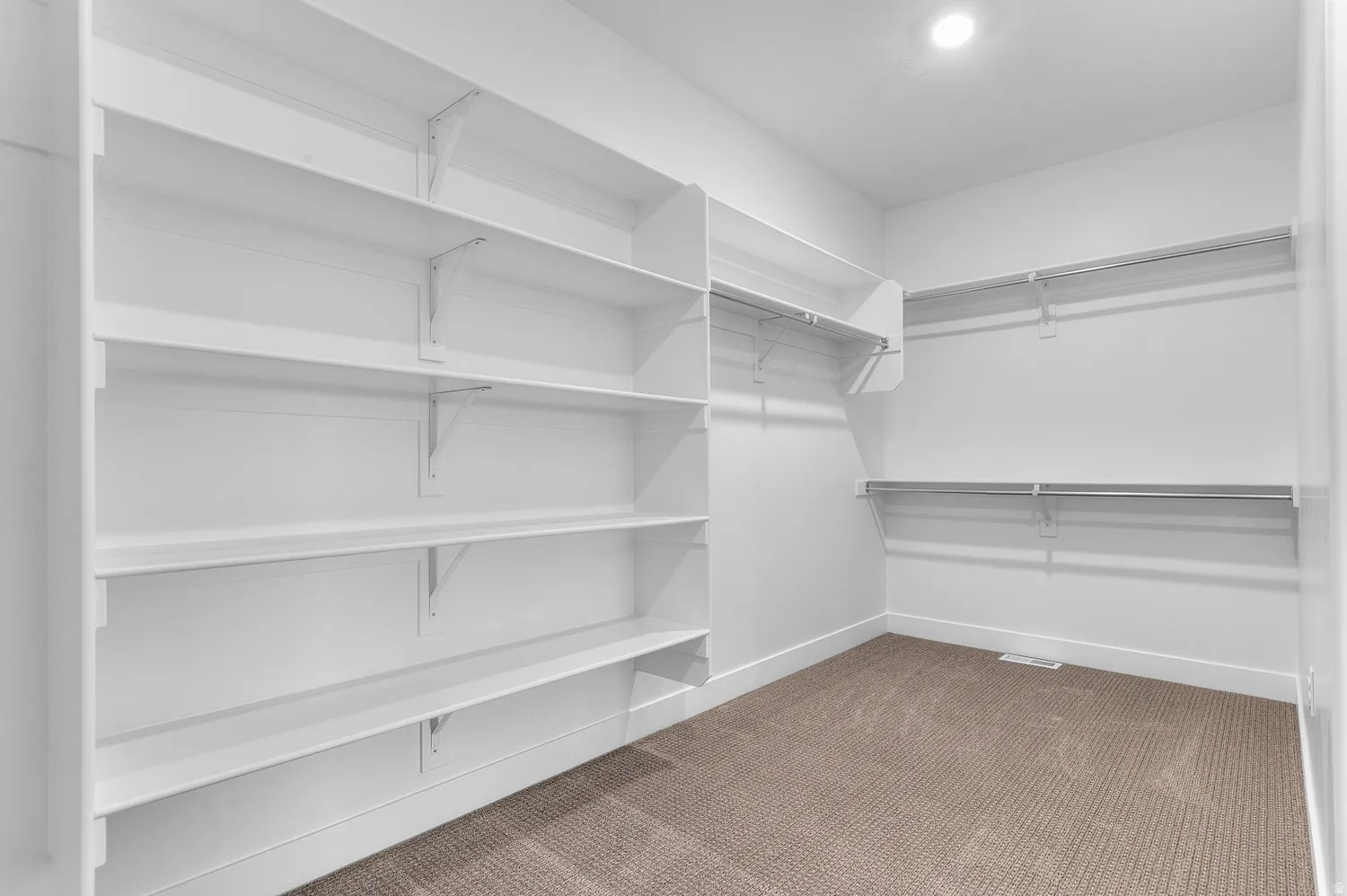 Walk in closet featuring light colored carpet