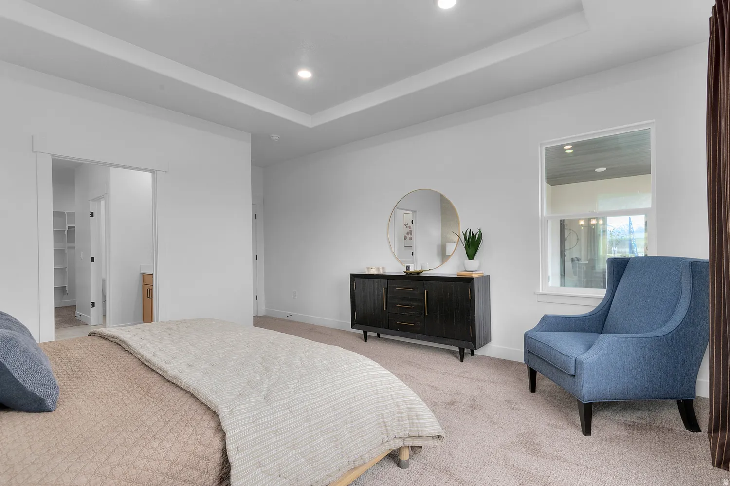 Carpeted bedroom featuring recessed lighting, a tray ceiling, connected bathroom, and a spacious closet