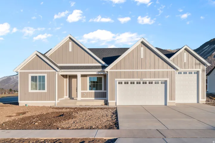 View of front of home featuring a garage, a mountain view, covered porch, and concrete driveway